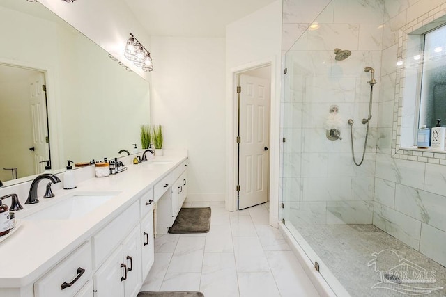 full bathroom with double vanity, tiled shower, marble finish floor, and a sink