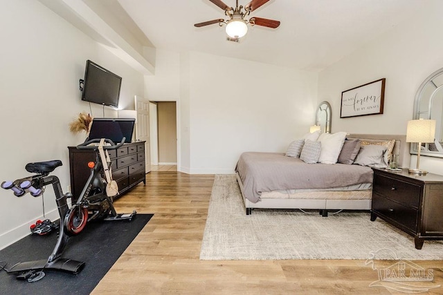 bedroom with ceiling fan, light wood-type flooring, baseboards, and lofted ceiling