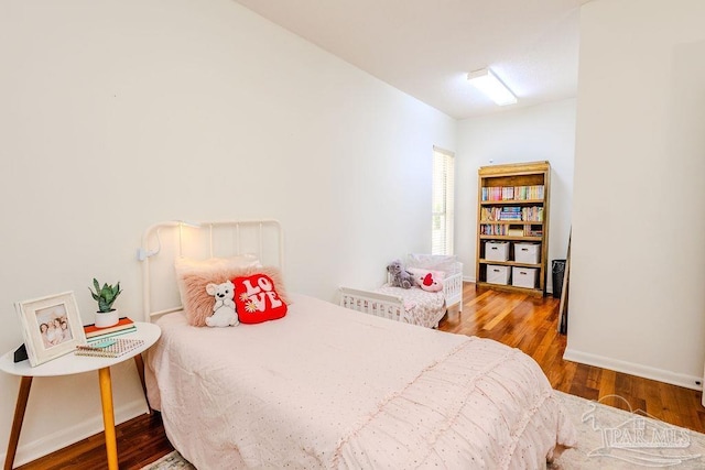 bedroom featuring baseboards and wood finished floors