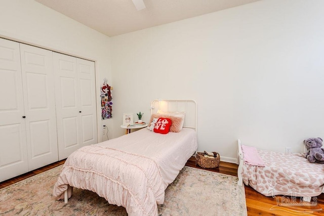 bedroom featuring ceiling fan, a closet, and wood finished floors