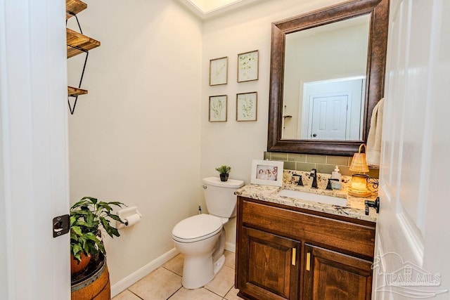 bathroom with baseboards, toilet, decorative backsplash, tile patterned floors, and vanity