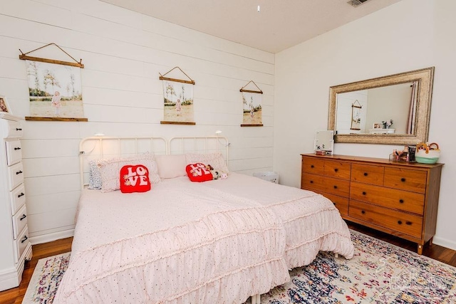 bedroom with visible vents, baseboards, and wood finished floors