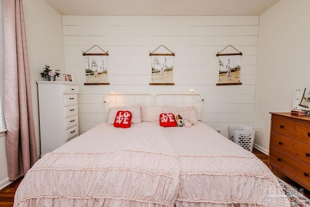 bedroom with baseboards and dark wood-style flooring