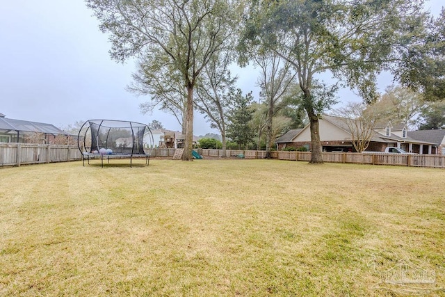 view of yard with a fenced backyard, a playground, and a trampoline