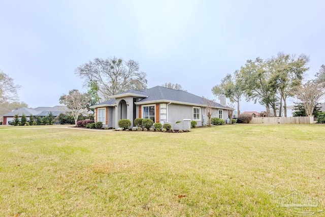 view of front facade featuring stucco siding, a front lawn, and fence