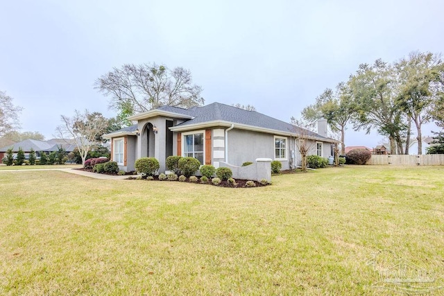 view of side of property with a yard, a chimney, stucco siding, and fence