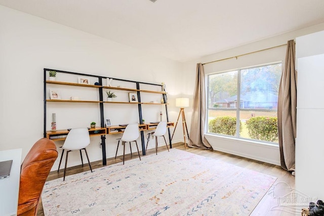 home office with baseboards and wood finished floors