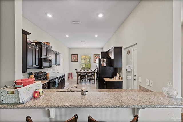 5798 Vendome Ct, Milton, FL 32583 - kitchen with a sink, light stone countertops, black appliances, and a notable chandelier