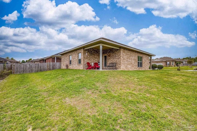 5798 Vendome Ct, Milton, FL 32583 - back of property with a patio area, brick siding, fence, and a lawn