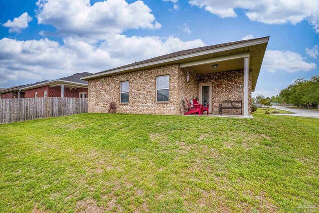 5798 Vendome Ct, Milton, FL 32583 - rear view of house with brick siding, fence, and a yard