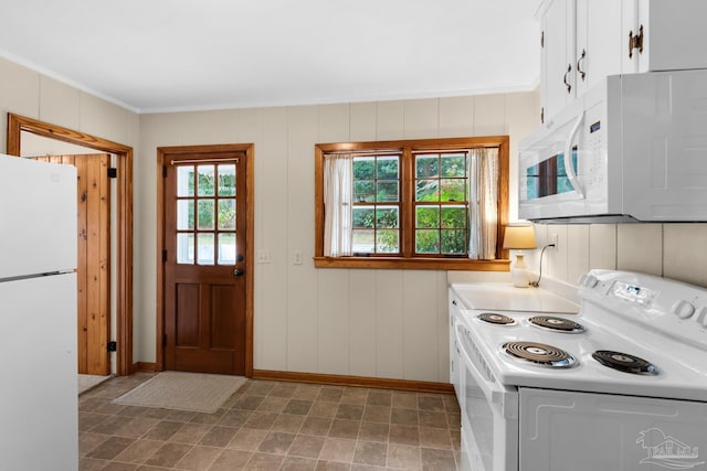 kitchen featuring white cabinetry, white appliances, ornamental molding, and wood walls