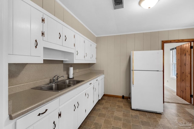 kitchen with sink, ornamental molding, white cabinets, and white fridge