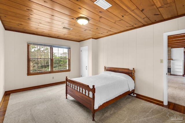 carpeted bedroom featuring wood ceiling and ornamental molding