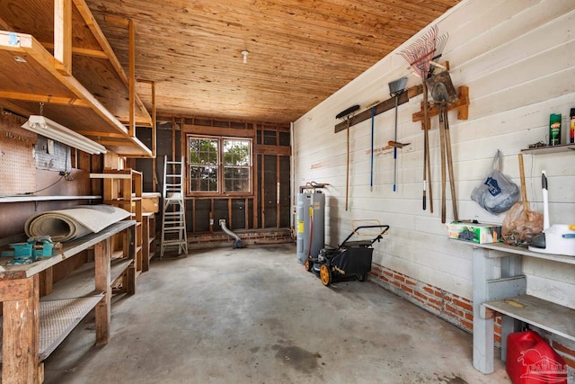 interior space with concrete floors, a workshop area, electric water heater, and wooden ceiling