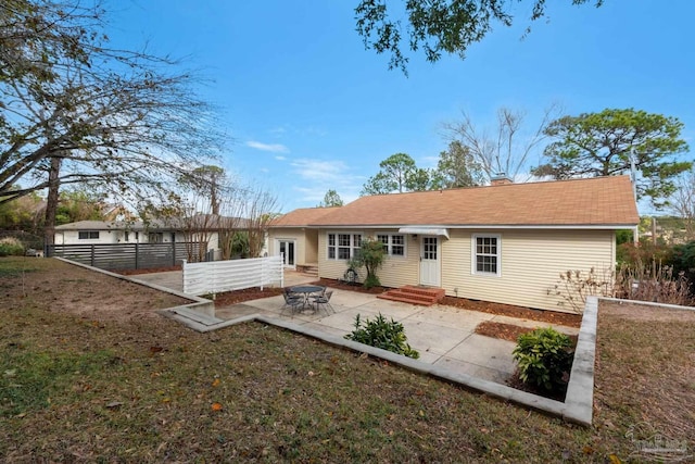 rear view of property with a yard and a patio area