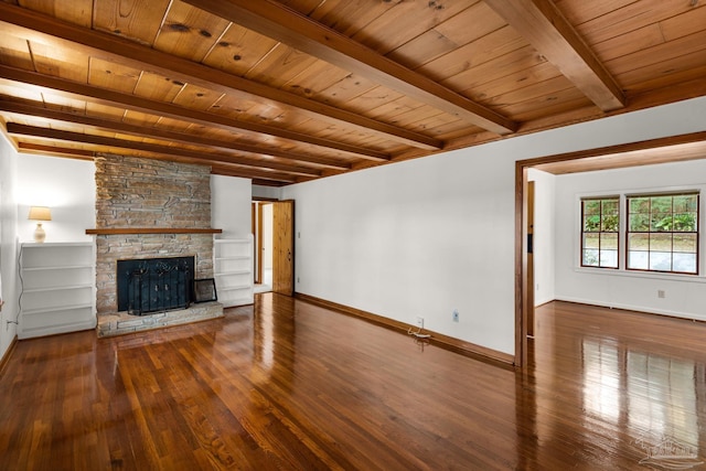 unfurnished living room featuring beamed ceiling, a stone fireplace, dark hardwood / wood-style flooring, and wooden ceiling