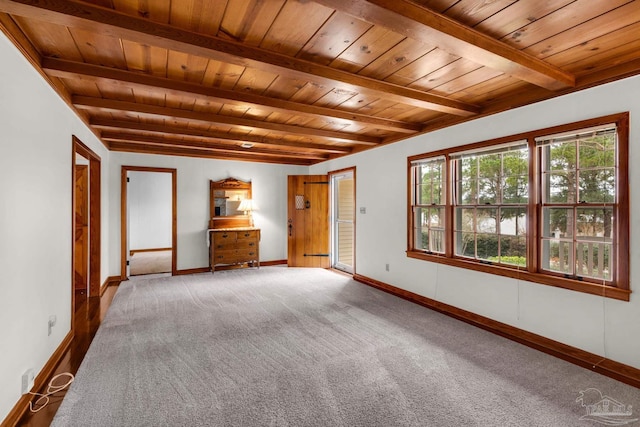 carpeted spare room featuring beamed ceiling and wooden ceiling