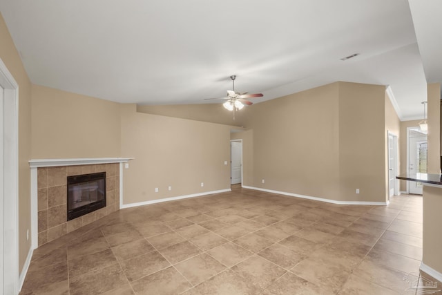 unfurnished living room featuring vaulted ceiling, light tile patterned floors, ceiling fan, and a fireplace