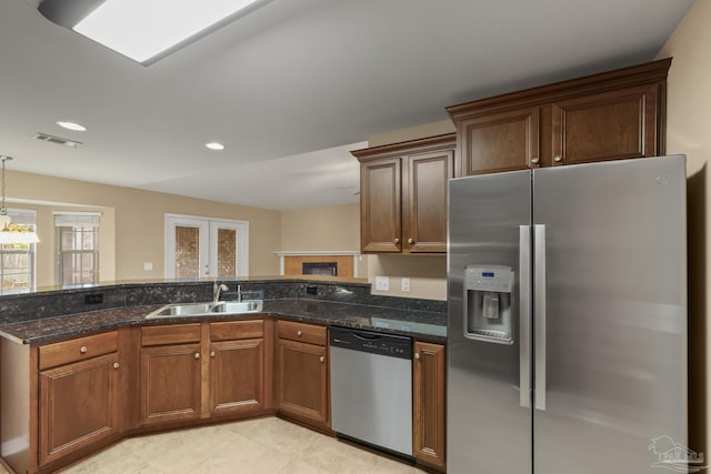 kitchen featuring pendant lighting, appliances with stainless steel finishes, sink, and dark stone counters