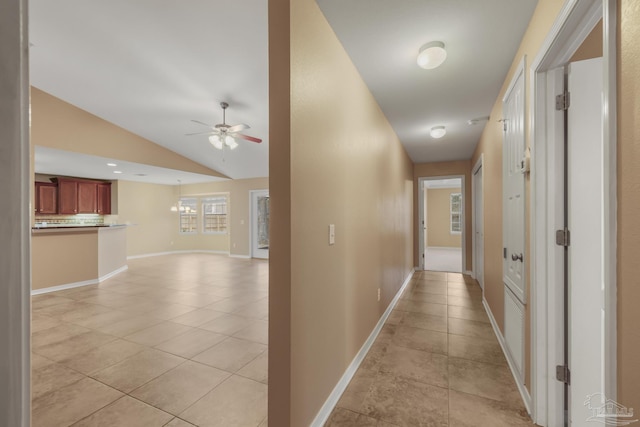 corridor with vaulted ceiling and light tile patterned floors