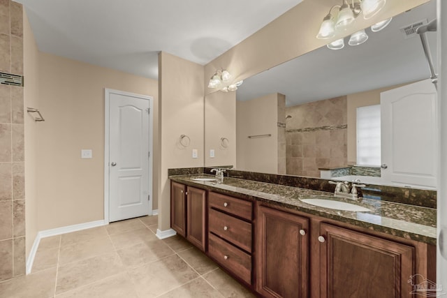 bathroom featuring tile patterned floors, vanity, and a tile shower