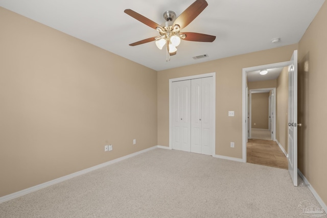 unfurnished bedroom with light carpet, a closet, and ceiling fan