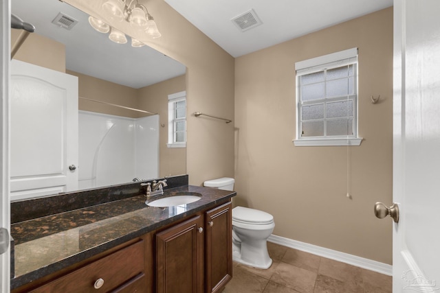 bathroom featuring vanity, tile patterned floors, toilet, and walk in shower