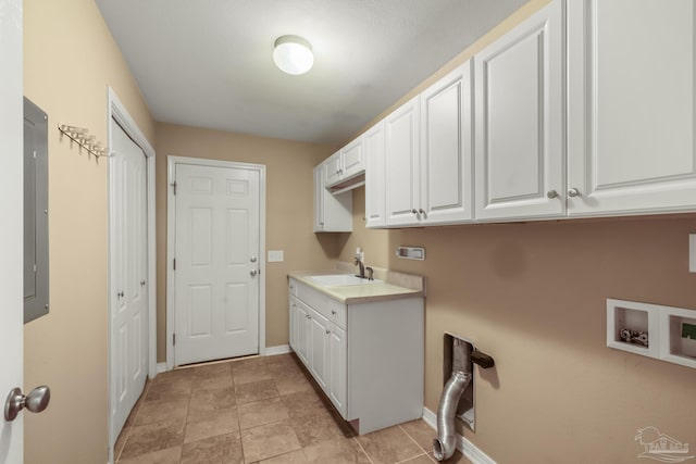 clothes washing area with sink, light tile patterned floors, electric panel, cabinets, and washer hookup