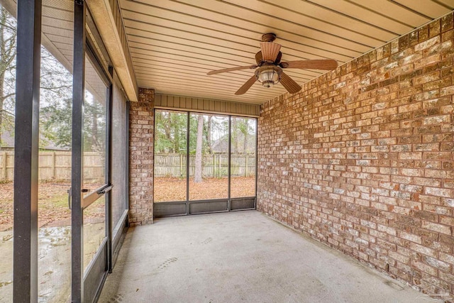 unfurnished sunroom with ceiling fan