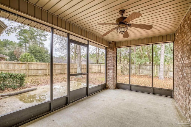 unfurnished sunroom featuring wooden ceiling and ceiling fan