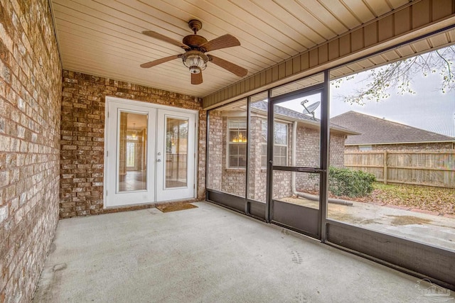 unfurnished sunroom featuring french doors, ceiling fan, a healthy amount of sunlight, and wood ceiling