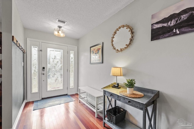 foyer featuring hardwood / wood-style floors and a textured ceiling