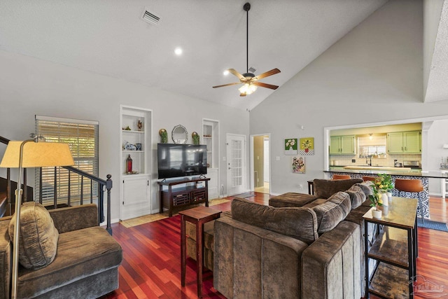 living room featuring wood-type flooring, high vaulted ceiling, built in features, and ceiling fan