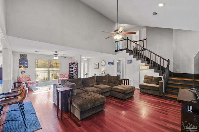 living room with ceiling fan, dark hardwood / wood-style flooring, and a high ceiling