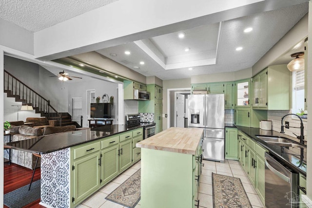 kitchen featuring stainless steel appliances, a center island, and green cabinets