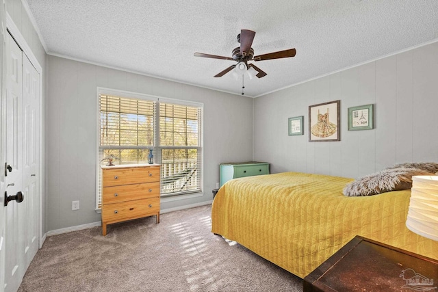 bedroom with crown molding, a textured ceiling, a closet, ceiling fan, and carpet