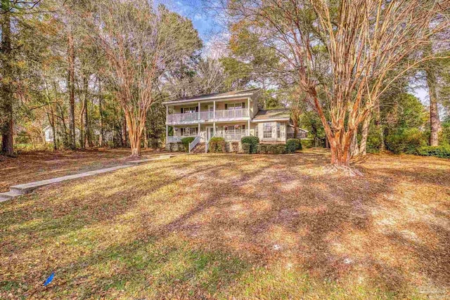 view of front property with a porch, a balcony, and a front lawn