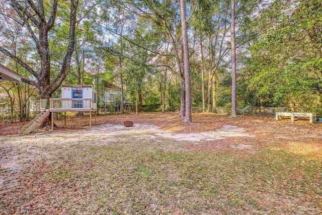 view of yard featuring a wooden deck and an outdoor fire pit