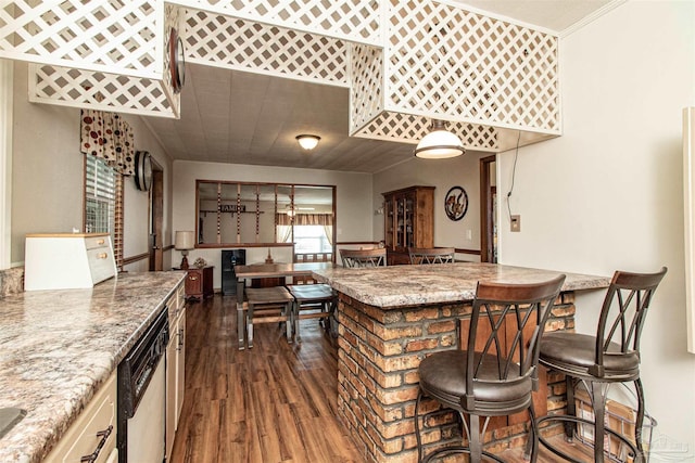 kitchen featuring dishwasher, dark hardwood / wood-style floors, light stone countertops, and ornamental molding