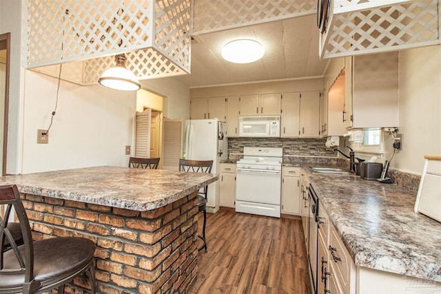 kitchen featuring white appliances, cream cabinets, sink, dark hardwood / wood-style floors, and decorative backsplash