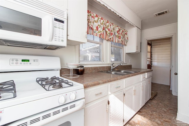 kitchen featuring white cabinetry, sink, and white appliances