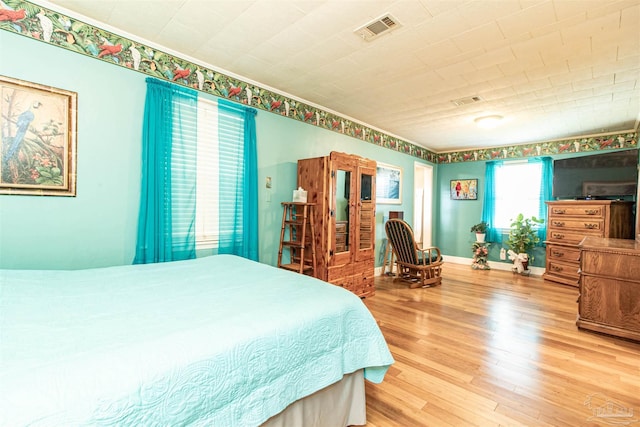 bedroom with hardwood / wood-style floors and multiple windows