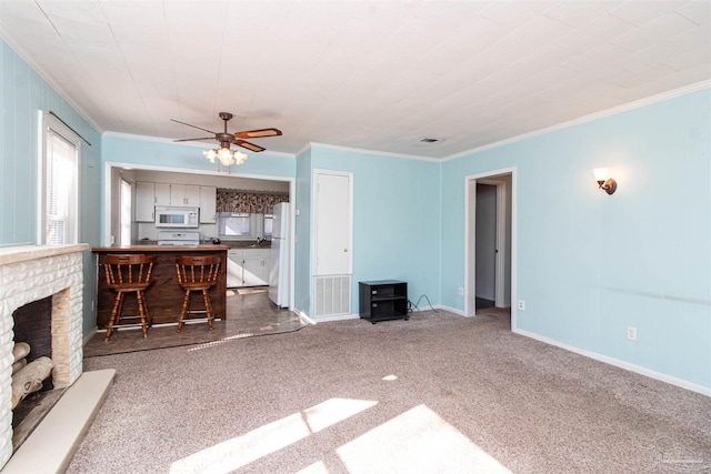 unfurnished living room featuring carpet flooring, ornamental molding, and a fireplace