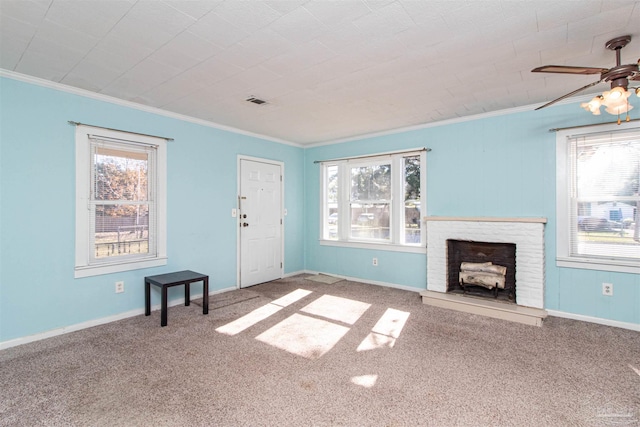 unfurnished living room featuring ceiling fan, ornamental molding, a fireplace, and carpet floors