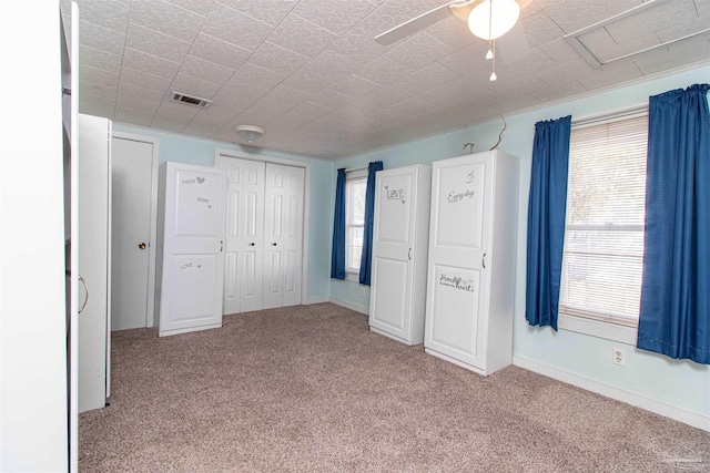 unfurnished bedroom with ceiling fan and light carpet