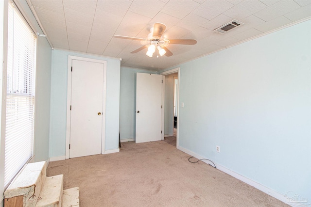 unfurnished bedroom featuring light carpet and ceiling fan