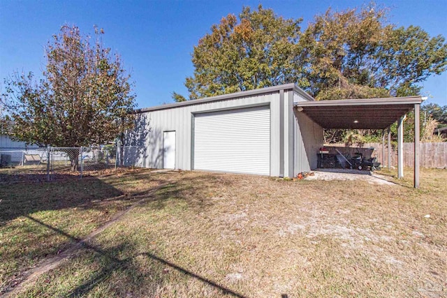 garage with a carport and a lawn