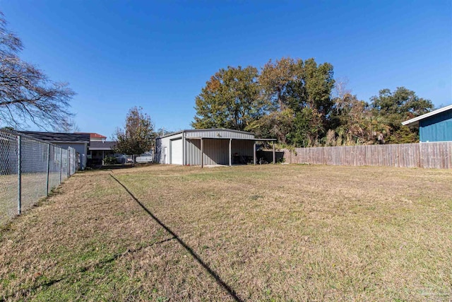 view of yard featuring a garage and an outbuilding