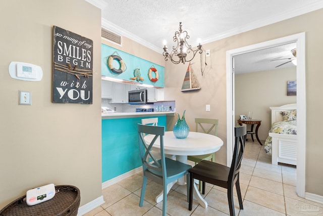 tiled dining area with ceiling fan with notable chandelier, a textured ceiling, and crown molding