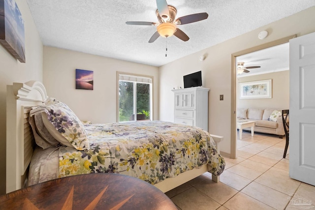 tiled bedroom with ceiling fan and a textured ceiling